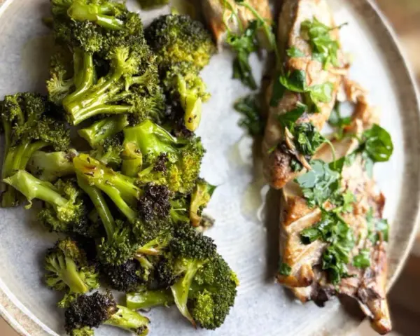 Brocoli al horno, tierno y dorado, junto a un filete de pescado con hierbas frescas.