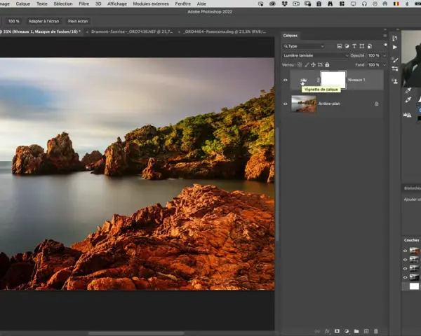 Paysage rocheux au bord de la mer, avec un ciel doux. L'interface Photoshop montre un calque "Vignette de calque", suggérant un effet soleil créé avec Photoshop.