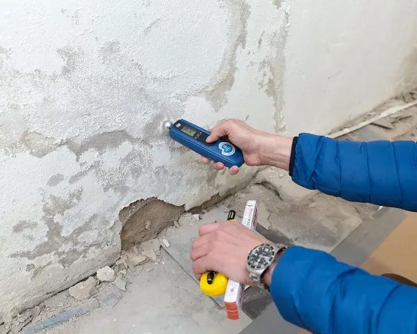 Feuchtemessung an einer Wand. Die isotec kosten pro qm hängen vom Ausmaß des Schadens ab.