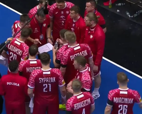 Drużyna piłki ręcznej Polska w czerwonych strojach z białymi detalami, podczas narady taktycznej przed meczem z Niemcami.