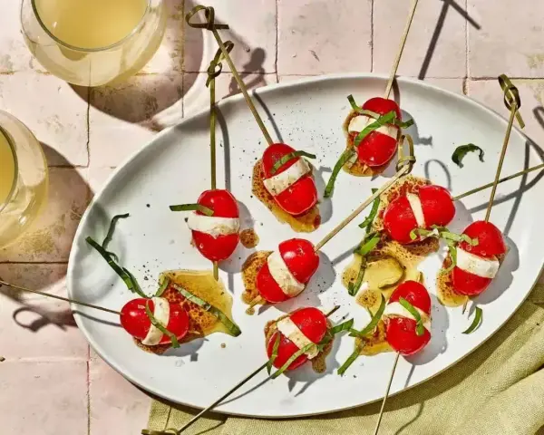 Proste przepisy na przekąski w 15 minut: szaszłyki caprese na chrupkim pieczywie z bazylią i sosem.