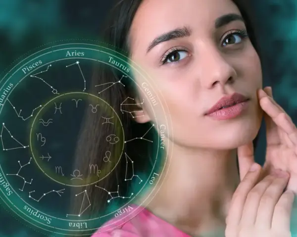 Kobieta z delikatnym dotykiem na policzku, obok niej krąg zodiaku. 6 lipiec znak zodiaku to Rak.