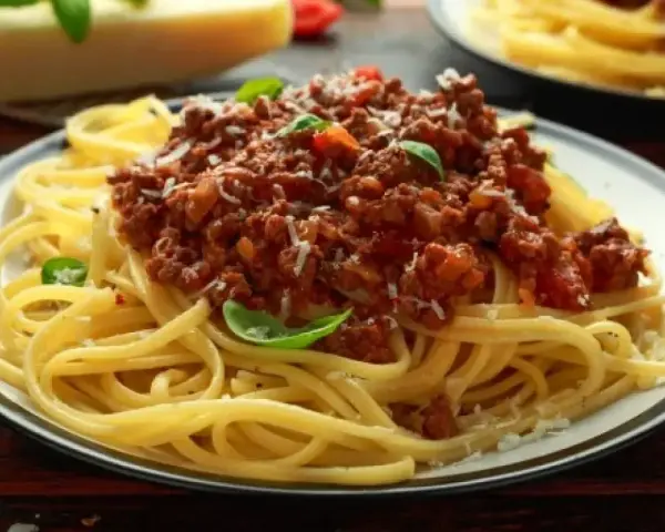 Pyszne spaghetti bolognese z mielonym mięsem, pomidorami i bazylią. Idealne przyprawy do spaghetti podkreślają smak dania.