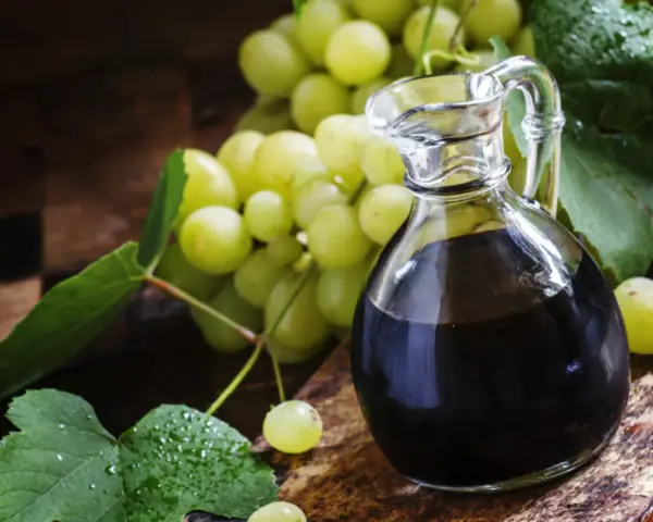 Ciemny płyn w karafce i winogrona. Szukasz, czym zastąpić ocet balsamiczny? Oto inspiracja.