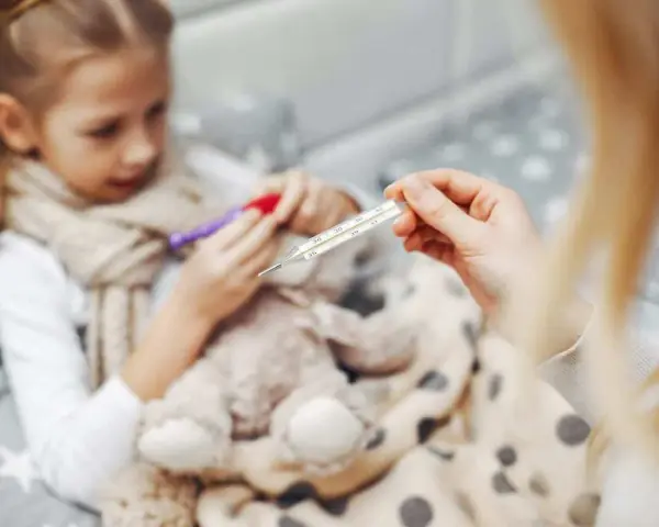 Chora dziewczynka z gorączką, mama mierzy temperaturę. Czy to rotawirus?