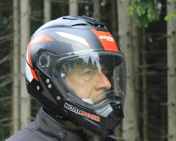 Uomo con casco Nolan, simbolo di sicurezza e avventura su due ruote. Il suo significato è protezione per ogni viaggio.