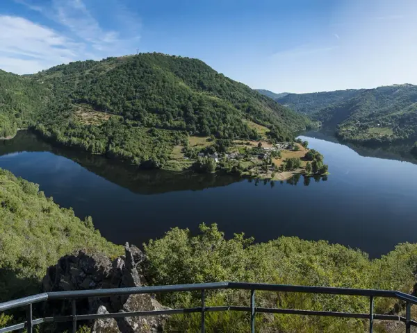 Vue panoramique des gorges de la Truyère, un lac paisible reflétant les collines verdoyantes. Idéal pour la randonnée.
