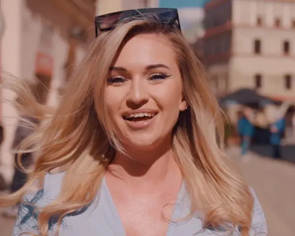 Uśmiechnięta blondynka w okularach na głowie, idealna do piosenki na 50 urodziny disco polo.