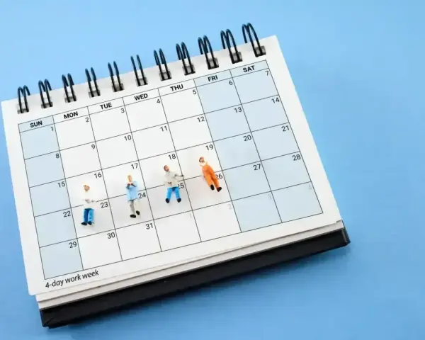 Miniaturki ludzi na kalendarzu z napisem "4-day work week". To karta nauczyciela zmian, która pokazuje, jak można zaplanować krótszy tydzień pracy.