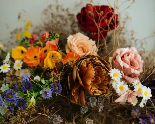 Un ramo de flores secas y artificiales, con tonos ocres, rosas, naranjas y morados. Una guía visual sobre como preservar flores para un recuerdo eterno.