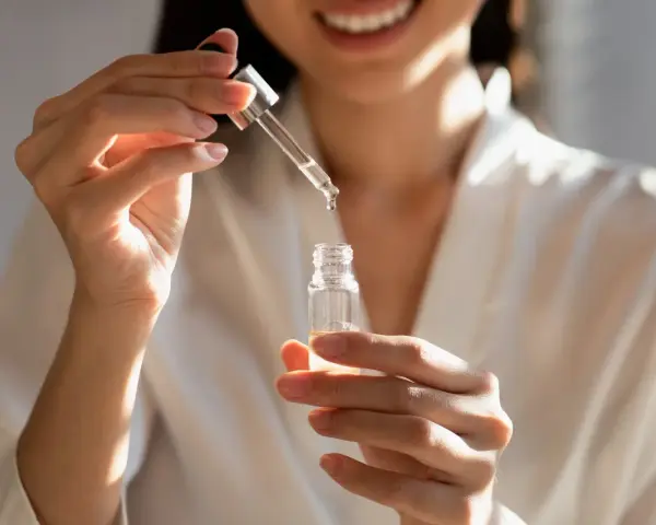 Kobieta aplikuje serum z kwasem fitynowym, dbając o swoją cerę.