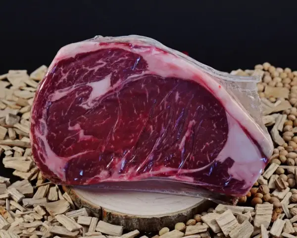 Bistecca di Chianina, un taglio pregiato, pronto per essere cucinato alla tedesca, su un letto di legnetti e noccioli.
