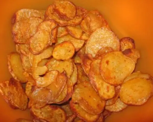 Knusprige, selbstgemachte Kartoffelchips in einer Schüssel. Perfekt zum Knabbern, wenn man Lust hat, Kartoffelchips selber machen.