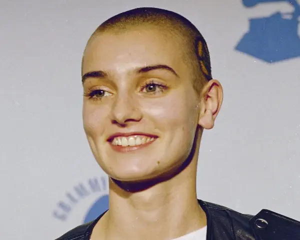 Uśmiechnięta Sinéad O'Connor z ogoloną głową, w czarnej ramonesce. Jej spojrzenie mówi, że nic nie porównuje się do Ciebie.