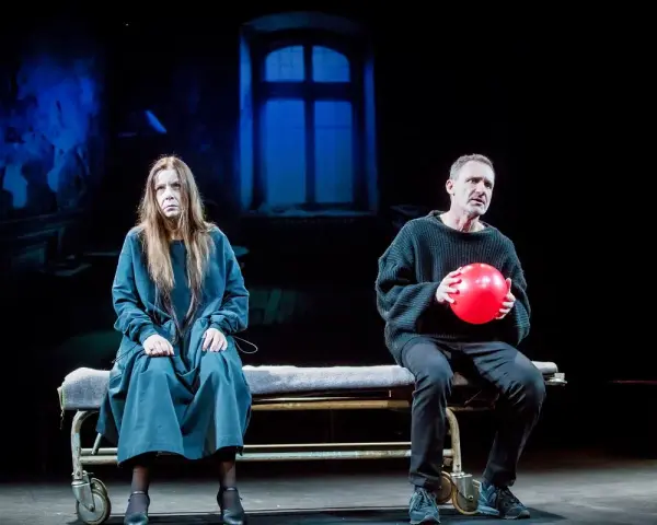 Agata Kulesza w teatrze, siedzi obok mężczyzny z czerwoną piłką.