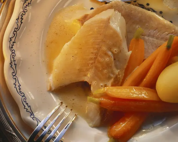 Zart gebratener Hecht mit Karotten und Kartoffeln, serviert in einer cremigen Sauce. Ein köstliches Gericht, das zeigt, wie man Hecht zubereiten kann.