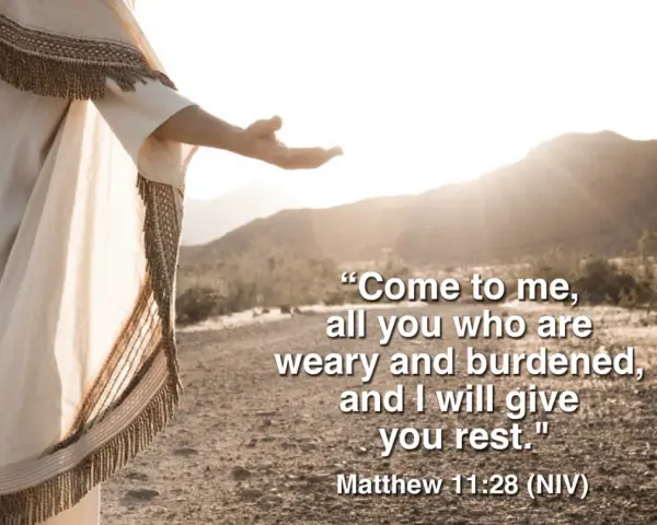 Jesus, in a flowing robe, extends an open hand in a desert landscape, offering rest as described in Matthew 11:28-30 meaning.