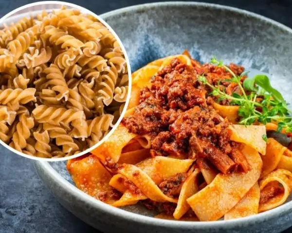 Pyszny makaron na redukcji z sosem bolognese. Widać też surowy makaron fusilli, idealny do zdrowych posiłków.