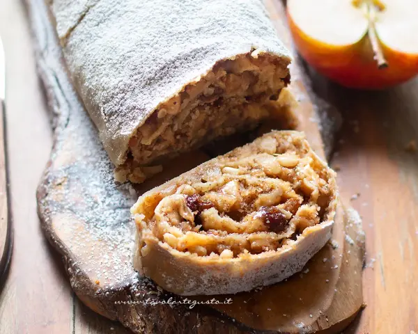 Un delizioso strudel di mele, cosparso di zucchero a velo, con un ripieno ricco di mele, uvetta e pinoli.