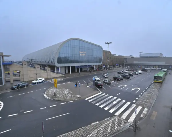 Dworzec Poznań Główny, z nowoczesną architekturą i parkingiem pełnym samochodów, gotowy na podróżnych do Nowego Tomyśla.