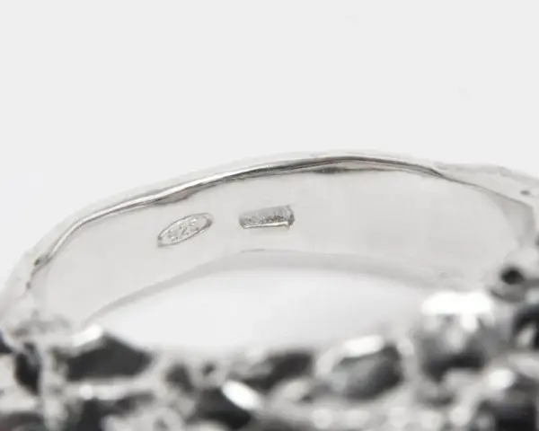 Anello in argento con incisione "925". Un numero argento e oro che brilla.
