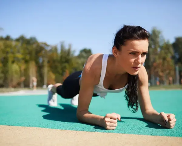 Kobieta wykonuje plank, idealne ćwiczenie na trening core dla początkujących.