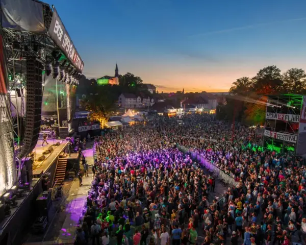 Ein riesiges Open Air Festival mit tausenden Besuchern. Die Bühne ist beleuchtet, die Menge feiert. Heute sind hier tolle Konzerte!