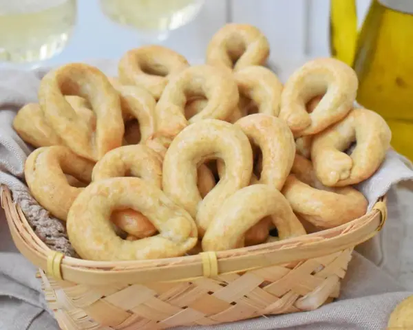 Koszyk pełen chrupiących taralli, idealnych do chrupania. Ten przepis na taralli to sekret włoskiej przekąski.
