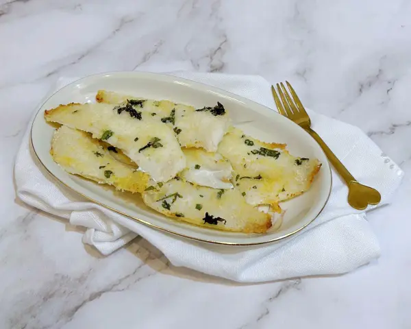 Delizioso merluzzo in friggitrice ad aria, croccante fuori e tenero dentro, guarnito con erbe aromatiche.