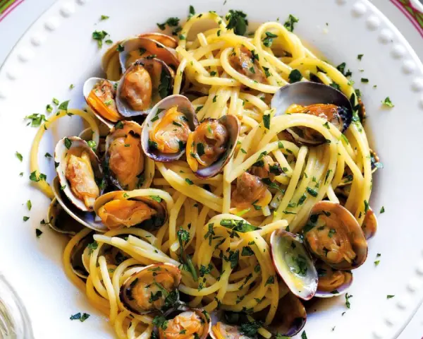 Spaghetti alle vongole surgelate, un piatto gustoso e veloce. Pasta dorata con molluschi freschi e prezzemolo tritato, pronto in pochi minuti.