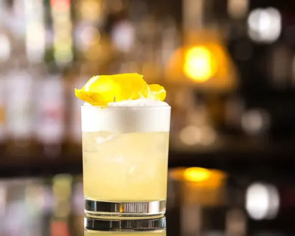 Klasyczny whisky sour przepis: orzeźwiający koktajl z pianką i skórką cytryny, idealny na każdą okazję.