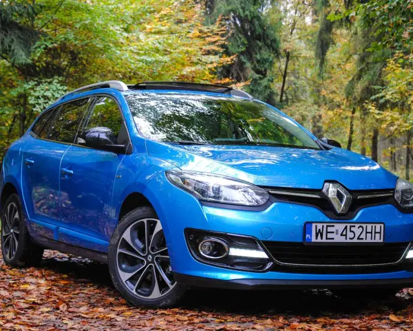 Niebieski Renault Megane 2 1.6 16v na tle jesiennego lasu.