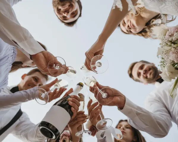 Różnica między poprawinami a wspólnym śniadaniem dla gości: toast szampanem z bliskimi, uśmiechy i bukiet panny młodej.