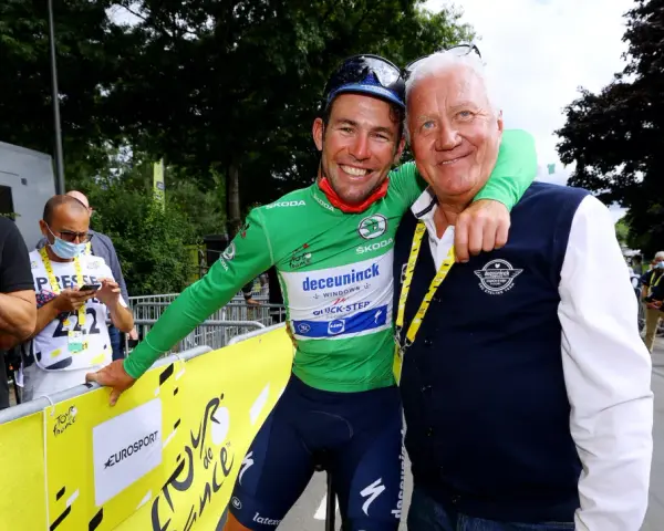 Cyclist in green jersey with Patrick Lefevere, both smiling.