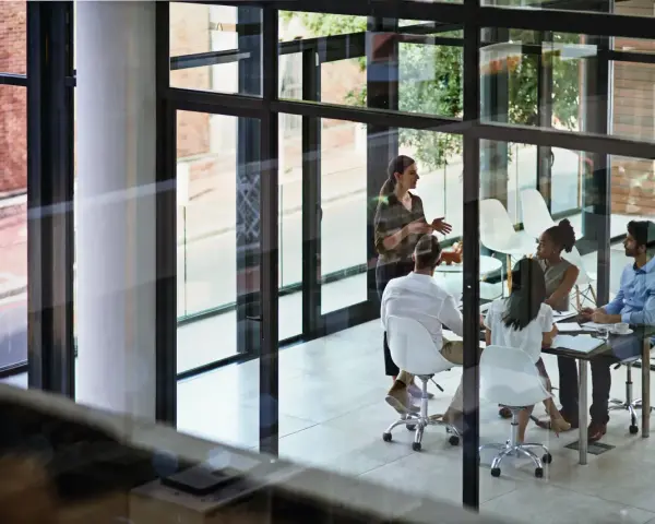 A team discusses network infrastructure solutions in a modern office meeting room.