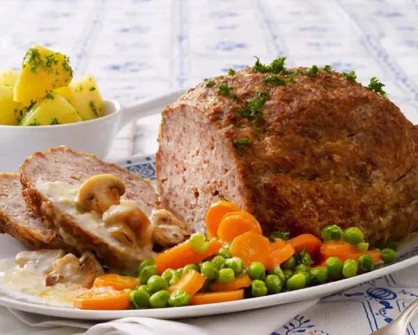 Herzhaftes Hackbraten-Mittagessen nach Omas Rezepten, serviert mit Salzkartoffeln, Pilzrahmsoße und Gemüse.