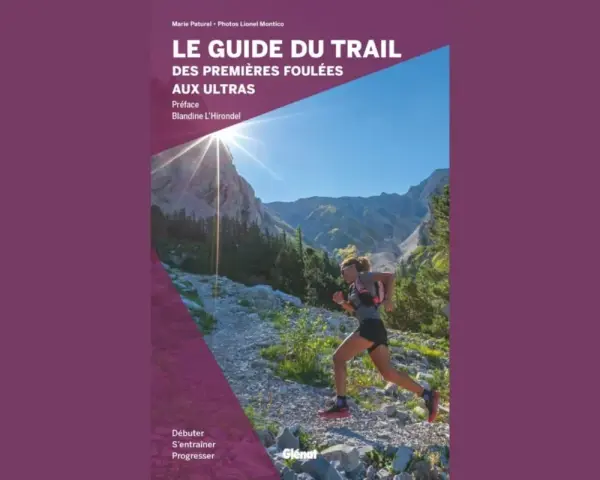 Couverture du livre "Le Guide du Trail", montrant une femme en pleine rando course en montagne sous un soleil éclatant.