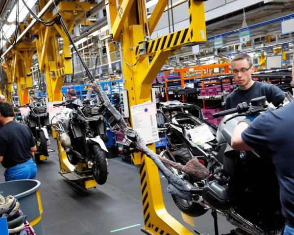 Männer arbeiten an Motorrädern in einer Fabrik. An Christi Himmelfahrt muss man anscheinend arbeiten.