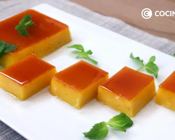 Delicioso tocino de cielo en porciones, decorado con hojas de menta fresca sobre un plato blanco.