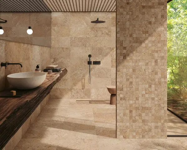 Salle de bain luxueuse avec carrelage en travertin. Le travertin, c'est quoi ? Une pierre naturelle chaleureuse et texturée.