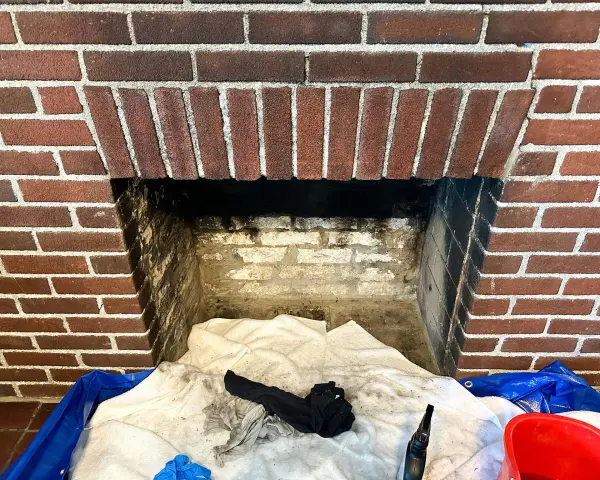 Camino in mattoni pronto per la pulizia. Il braciere è vuoto, ma c'è un allarme per la stufa a pellet.