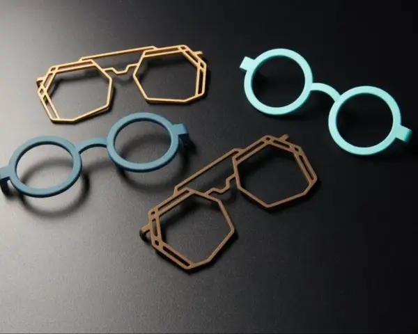 Four colorful, modern 3d printing glasses frames in geometric and round shapes, displayed on a dark surface.
