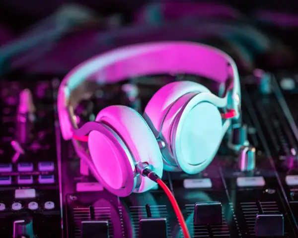 Słuchawki na mikserze, gotowe do tworzenia pulsującej muzyki elektronicznej w neonowym świetle.