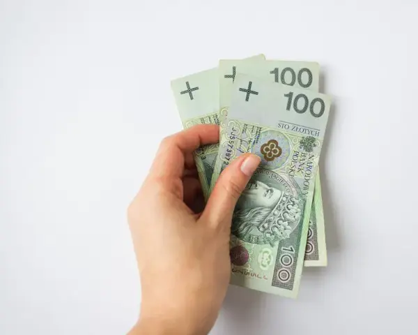 Dłoń trzyma banknoty 100 zł. To 300 zł, wystarczające na wiele przyjemności, nawet dla osoby w każdym wieku.