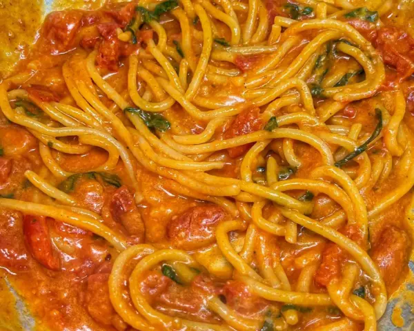 Spaghetti avvolti in un sugo cremoso di pomodoro e basilico, un invitante piatto di pasta allo scarpariello.
