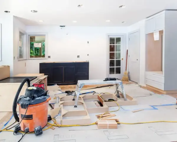 Chantier d'un appartement en rénovation : armoires sombres, structure en bois, aspirateur, outils. Idéal pour des conseils rénovation appartement.