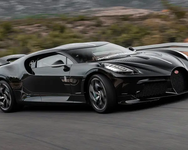 Czarny Bugatti La Voiture Noire pędzi po krętej drodze. Zastanawiasz się, ile kosztuje ten cud motoryzacji?