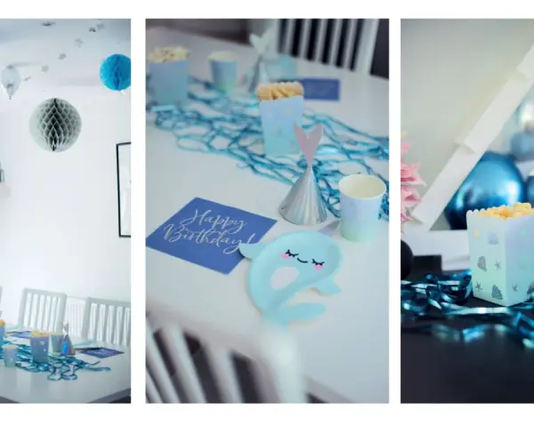Blå och silverfärgade ballonger, stjärnor och honkoms dekorationer skapar en festlig stämning. Bordet är dukat med havstema, inklusive popcornaskar och en "Happy Birthday"-servett.