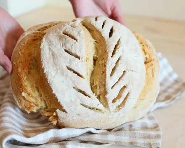 Pane fatto in casa, fragrante e dorato, con tagli che ricordano la ricetta della nonna.