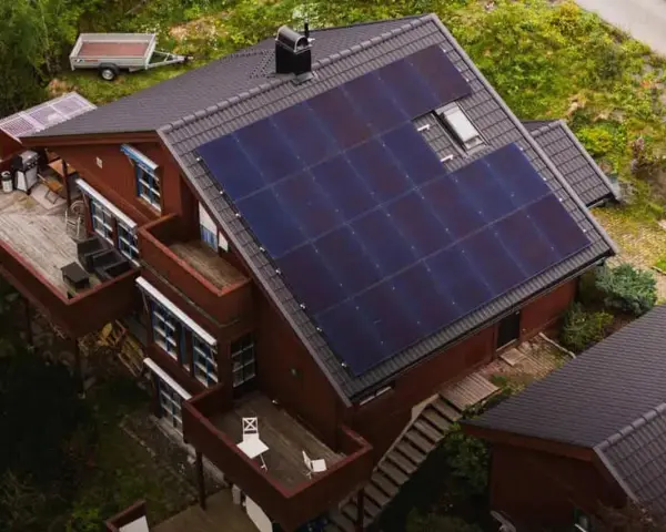 Dom z panelami fotowoltaicznymi na dachu. To rozwiązanie, co to fotowoltaika, pozwala na produkcję własnej energii elektrycznej ze słońca.